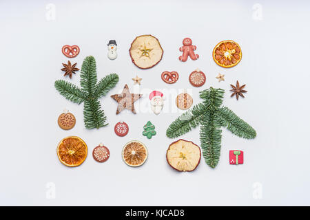 Mise en page créative de noël faites avec des branches de sapin, fruits secs, épices d'hiver et des bonbons en forme de santa, Gingerbread Man, pretzel et Noël tr Banque D'Images
