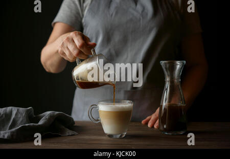 Caucasian woman pouring coffee en latte Banque D'Images