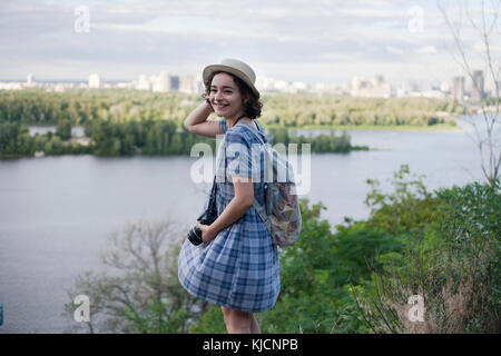 Portrait of a young woman carrying caméra à proximité de river Banque D'Images