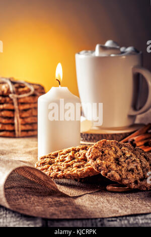 Automne hiver de la vie toujours recette maison gingembre biscuits au miel et de bagel, le cacao café tasse avec de la guimauve sur cuisine table en bois Banque D'Images