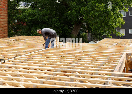 Loin Caucasian man hammering frame at construction site Banque D'Images