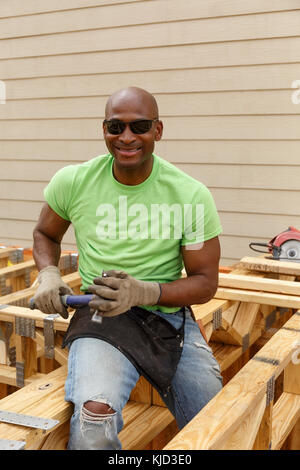 Black man posing with hammer at construction site Banque D'Images