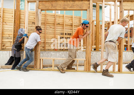 Les bénévoles encadrées poussant wall at construction site Banque D'Images