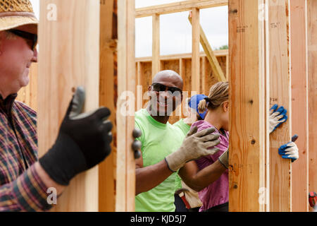 Les bénévoles holding wall at construction site Banque D'Images