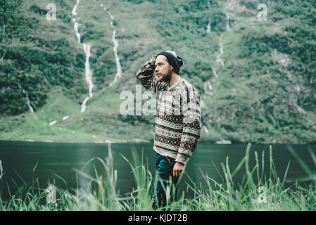 Pensive Caucasian man standing near river Banque D'Images