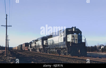 Cette photographie capture la locomotive GP40 127 de Richmond, Fredericksburg, and Potomac Railroad (RF&P) tirant un train de marchandises en direction sud à Guinea, Virginie, le 12 janvier 1969. L'image représente un moment important dans l'histoire du chemin de fer américain, mettant en valeur le transport de marchandises au milieu du XXe siècle. Banque D'Images