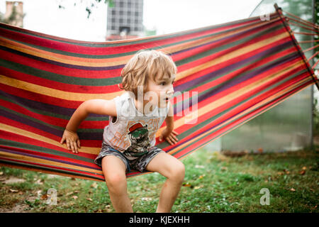 Young boy sitting in hammock Banque D'Images