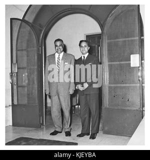 Cette photographie de 1959 montre le président égyptien Gamal Abdel Nasser recevant un journaliste indien et sa femme. L'image capture un moment diplomatique pendant le mandat de Nasser, symbolisant les relations internationales de l'Égypte dans l'ère post-coloniale. Banque D'Images