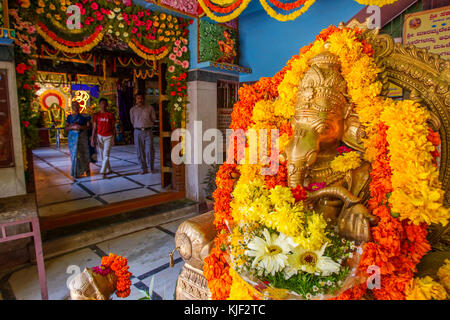 Les Indiens se rendant sur Shri Circle Maramma avec un temple décoré de fleurs Image de Ganesha Dans l'avant-plan, Bangalore, Karnataka, Inde Banque D'Images