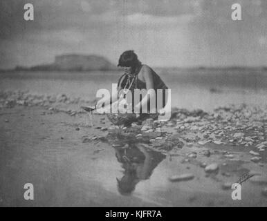 Photographie d'une femme amérindienne qui récolte de l'eau dans un pot d'argile provenant d'une rivière très peu profonde, intitulée « In the Grey Morning, A San Ildefonso Indian Maiden of New Mexico remplissant son pot des eaux peu profondes du Rio Grande », par Edward S Curtis, Nouveau-Mexique, 1905. De la bibliothèque publique de New York. Banque D'Images