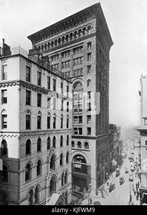 Une photographie extérieure du bâtiment Ames, il a été achevé en 1893 et a été le premier gratte-ciel de la ville, c'est un bâtiment de 13 étages qui a commencé comme un immeuble de bureaux mais a depuis été converti en un hôtel de luxe, On peut voir des rues animées de piétons et de voitures à cheval s'étendant au loin, Boston, Massachusetts, 1905. Banque D'Images