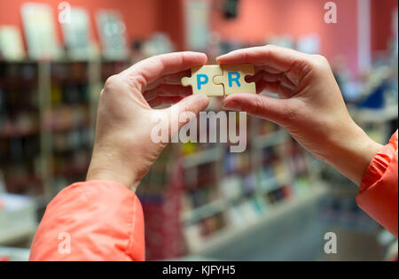 Woman hold mot puzzle pr en librairie. Banque D'Images