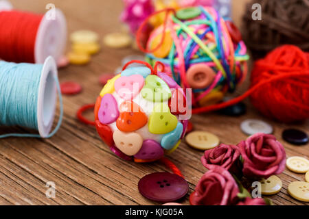 Libre de quelques boules de noël faites à la main, fait avec ribbon bow, cordes et boutons de différentes couleurs, et un tas de différents articles de mercerie sur Banque D'Images