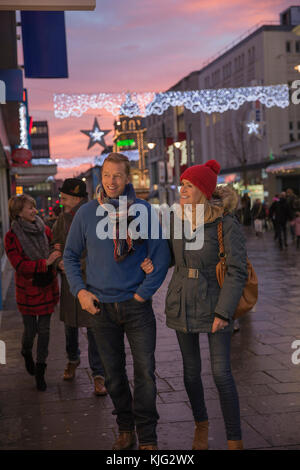 D'âge mûr sont d'un shopping d'hiver sur une soirée à l'époque de Noël. Banque D'Images