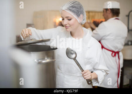 Femme la cuisine dans une cuisine de cantine Banque D'Images