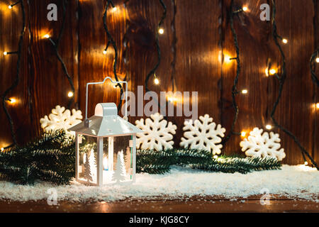 Lanterne à bougie de Noël et des branches d'arbre de Noël, la neige, flocon de neige et décorations sur fond flou Lumières floues. espace libre Banque D'Images
