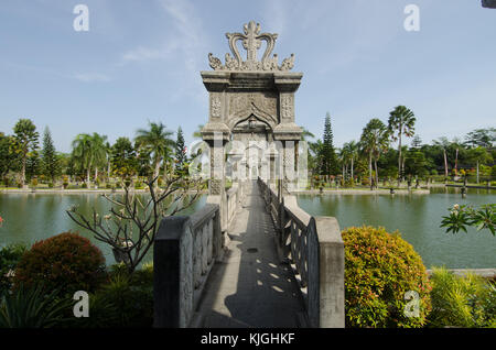 Pont en pierre sculptée sur étang artificiel dans les jardins du palais de ujun, à Bali, en Indonésie. Banque D'Images