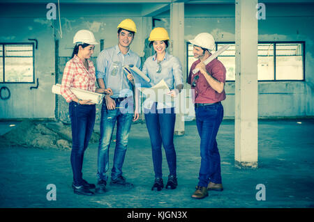 Construction professionnelle multiethnique des ingénieurs qui travaillent avec des collègues d'équipe et de l'équipement plan directeur sur le chantier, de l'industrie Banque D'Images