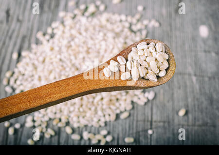 Les grains de l'orge perlé dans cuillère en bois Banque D'Images