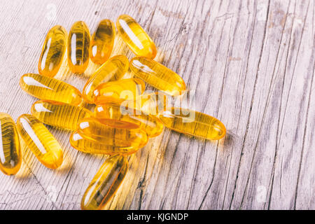 Close up of omega-3 fish oil capsules fat sur planche de bois Banque D'Images