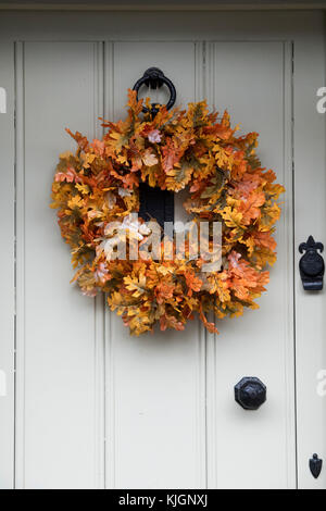 Automne tissu feuille de chêne couronne sur la porte d'un chalet dans la région des Cotswolds, Gloucestershire, Angleterre Banque D'Images