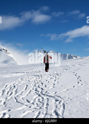 Avec skieur skis sur l'épaule allez jusqu'au haut de la montagne enneigée au soleil de nice 24. Montagnes du Caucase en hiver, la Géorgie, la région Gudauri, Mt. Kudebi. Banque D'Images