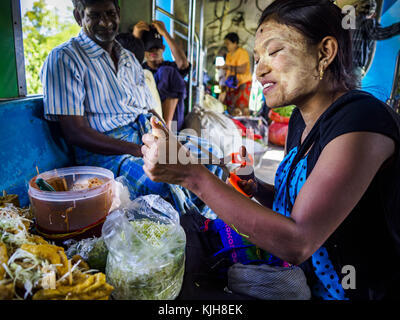 Yangon, Yangon, Myanmar région. 25Th nov, 2017. un snack-vendeur prépare une commande pour un client sur le train circulaire de Yangon yangon. Le train circulaire est un 45,9 km (28,5 mi) 39-station du système de boucle à deux voies relie des villes satellites et les banlieues au centre-ville. Le train a été construit durant la période coloniale britannique, la seconde voie a été construit en 1954. les trains en ce moment exécuter les deux sens (sens horaire et anti-horaire) autour de la ville. Les trains sont le moyen le moins coûteux d'obtenir à travers yangon et ils sont très populaires auprès de la classe ouvrière de Yangon. environ 100 000 personnes ride th Banque D'Images