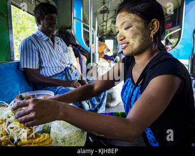 Yangon, région de Yangon, Myanmar. 25 novembre 2017. Un vendeur de snacks prépare une commande pour un client sur le train circulaire de Yangon. Le Yangon Circular train est un système de boucle à deux voies de 45 kilomètres (28,5 mi) de 39 stations qui relie les villes satellites et les banlieues au centre-ville. Le train a été construit pendant la période coloniale britannique, la deuxième voie a été construite en 1954. Les trains circulent actuellement dans les deux sens (sens horaire et sens antihoraire) autour de la ville. Les trains sont le moyen le moins cher de traverser Yangon et ils sont très populaires auprès de la classe ouvrière de Yangon. Environ 100 000 personnes parcourent th Banque D'Images