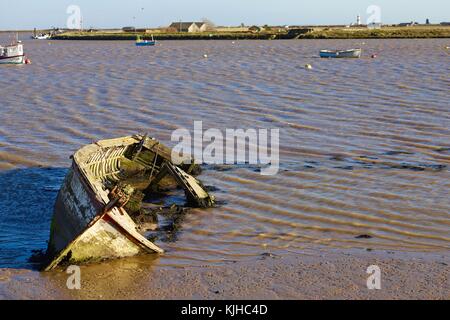 Un bateau en bois abandonné abandonné abandonné sur ses côtés dans la rivière Muddy ADLE à Orford Quay. Suffolk, Royaume-Uni. Banque D'Images