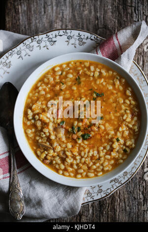 Citrouille, aux champignons et à l'orge soupe dans un bol blanc sur une table en bois. Banque D'Images