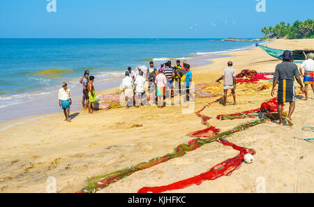 Bentota, Sri Lanka - 6 décembre 2016 : les pêcheurs tirer manuellement le montant net hors de l'océan et d'envisager la réussite de leur capture, le 6 décembre dans être Banque D'Images