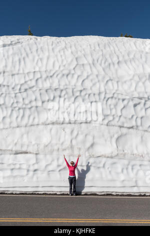 Femme se place en avant de grands snow drift à côté de effacée road Banque D'Images