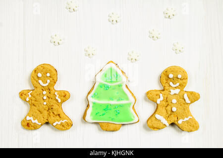 Gingerbread men amis de l'arbre de Noël sur une table en bois blanc Banque D'Images