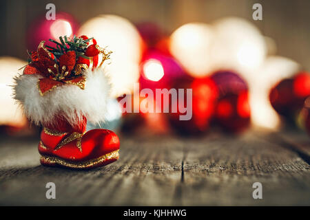 Noël rouge boo sur planche de bois rustique. soft bokeh lights et babioles en arrière-plan. Ce peut être utilisé comme Noël ou Nouvel an carte de vœux. Banque D'Images