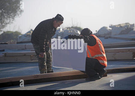 Greymouth, Nouvelle-Zélande, le 17 août 2014 : les constructeurs non identifié, vérifier leurs plans sur un matin glacial près de Greymouth, Nouvelle-Zélande Banque D'Images