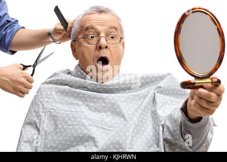 Choqué homme mûr ayant une coupe et en se regardant dans un miroir isolé sur fond blanc Banque D'Images