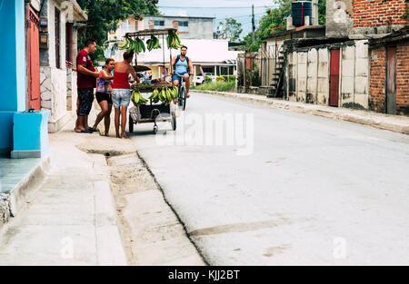 Las Tunas, Cuba - septembre 2017 : les gens qui achètent des fruits. man riding bicycle en arrière-plan. Banque D'Images