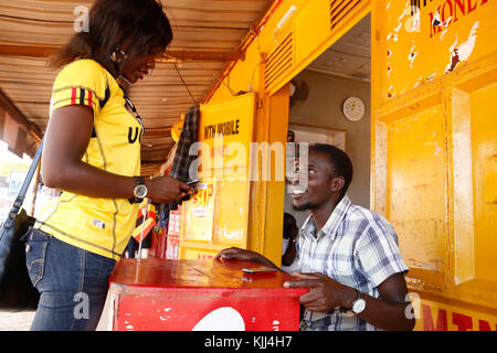 Femme ougandaise l'envoi d'argent par téléphone cellulaire. L'Ouganda Banque D'Images