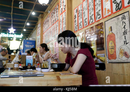 Woamn prenant le déjeuner dans un restaurant japonais. Ho Chi Minh Ville. Le Vietnam. Banque D'Images