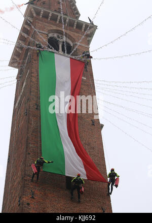 Vicenza, VI, Italie - 4 décembre 2015 : Les pompiers avec un grand drapeau italien et la tour de l'ancien palais appelé Basilique palladienne Banque D'Images