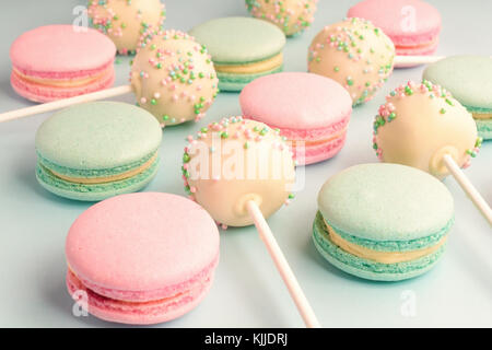 Close-up de macarons mélangé avec cake pops avec du glaçage sur des bâtons Banque D'Images