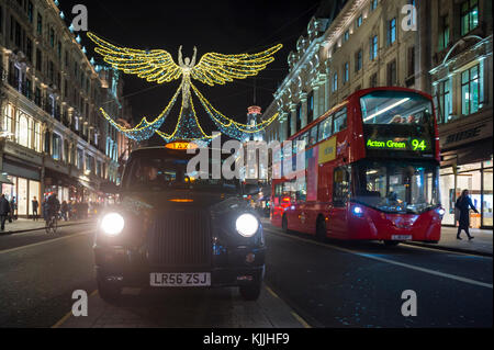 Londres - le 21 novembre 2017 : double decker bus et taxis noirs de la confiture les rues sous les anges de noël scintillantes illuminant le distr shopping haut Banque D'Images