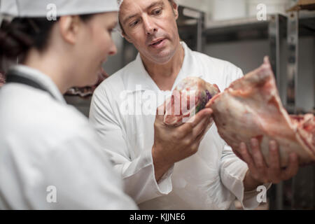 L'homme et la femme à parler de la viande dans une boucherie de l'entrepôt Banque D'Images