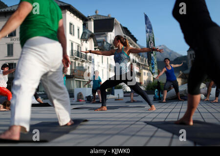 Grande classe de yoga en plein air strecthing armes. Saint-Gervais Mont-Blanc. La France. Banque D'Images