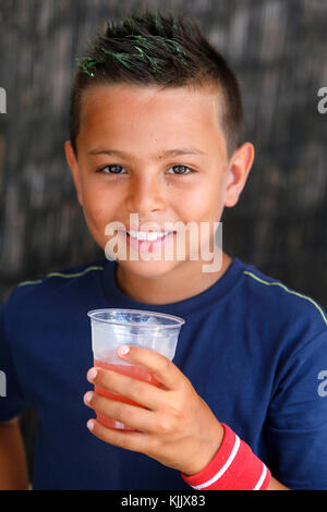 Jeune garçon de 9 ans boire du jus. Banque D'Images