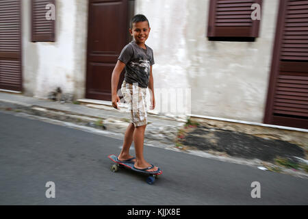 Jeune garçon de 9 ans sur une planche à roulettes. Banque D'Images