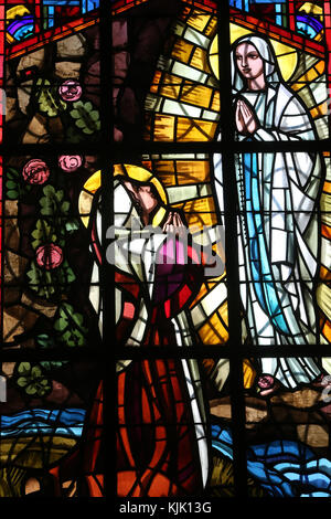 La cathédrale de Dalat. Vitrail. Notre Dame de Lourdes : une image représentant Marie apparaissant sur la grotte, en face de Bernadette Soubirous. Dalat. Banque D'Images