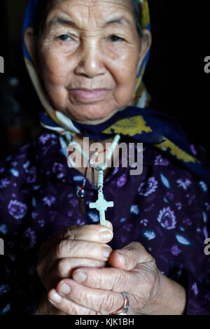 Vieille Femme catholique avec un crucifix dans les mains. Kon Tum. Le Vietnam. Banque D'Images