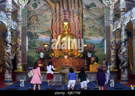 Linh Phuoc pagode bouddhiste. Assis golden buddha figure dans le hall principal. Les fidèles de prier le Bouddha. Dalat. Le Vietnam. Banque D'Images