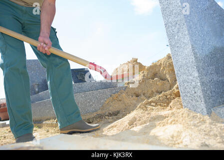 L'homme sable pelleter dans cimetière Banque D'Images